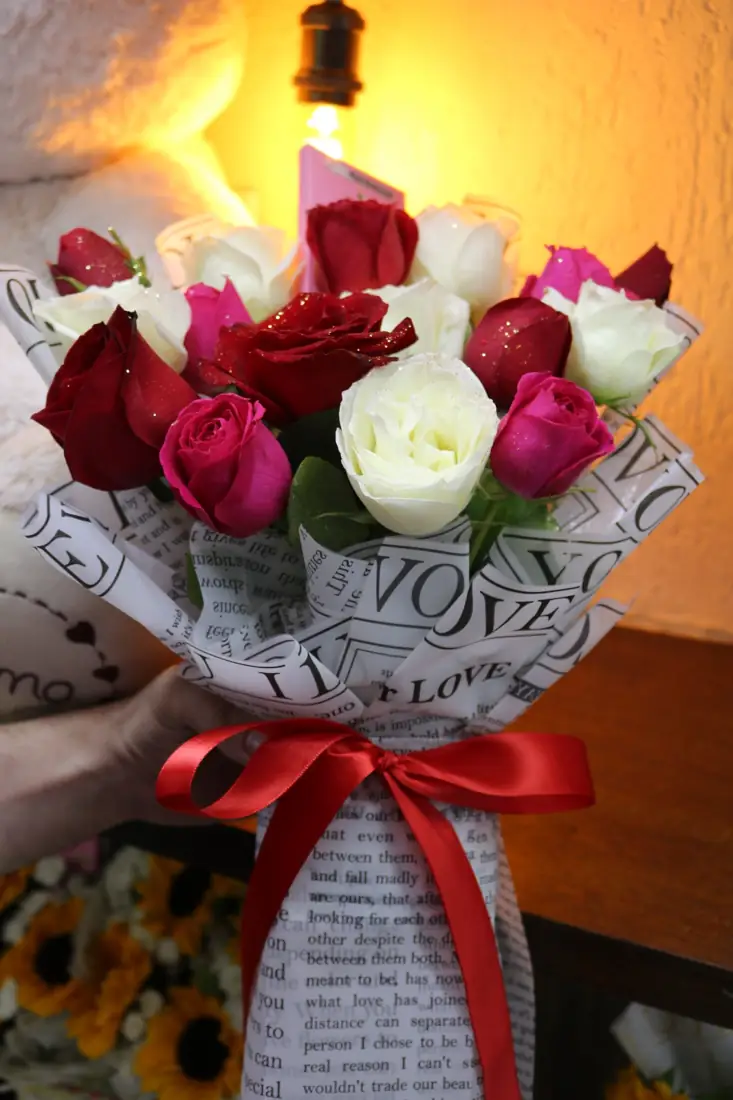 Buquê de rosas com papel estampado e laço vermelho