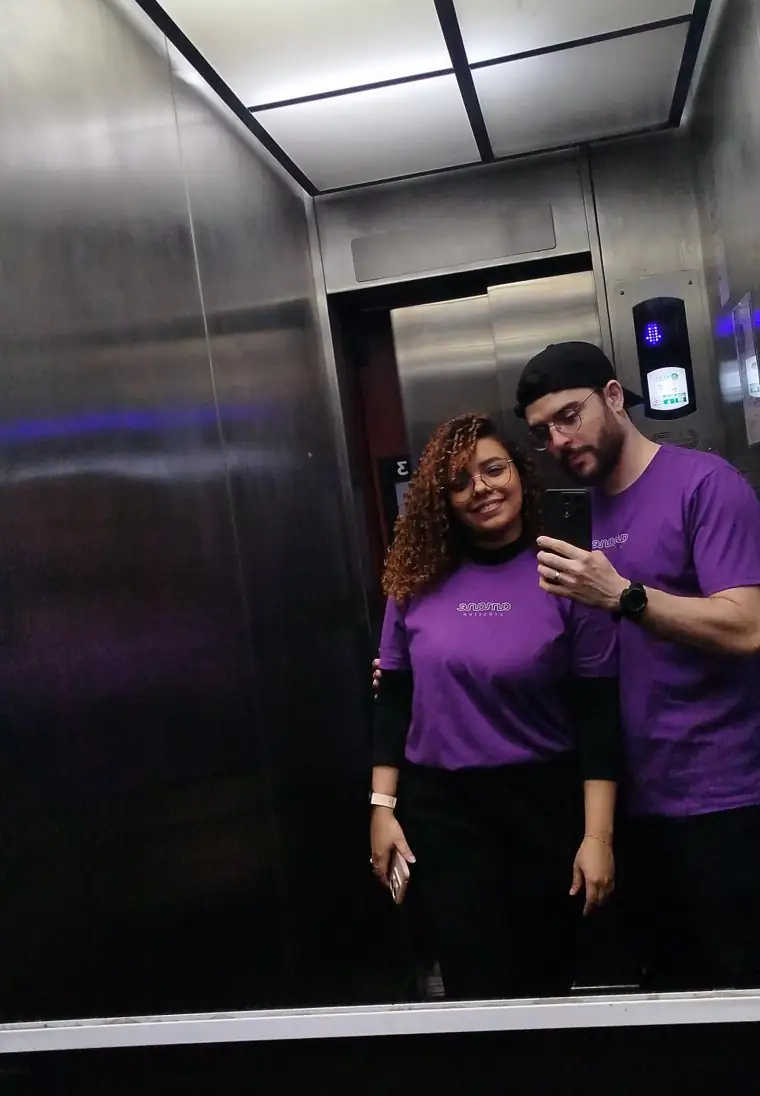 Amanda e Jonne, fundadores da Amane Creative, com camisetas roxas da agência